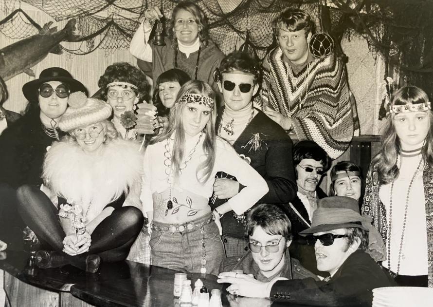 A black and white photo of a 1960's party.