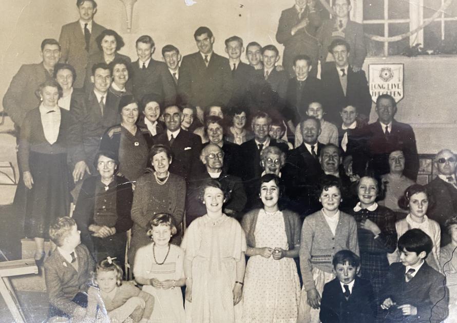 Black and white photo of various people posing for a photo for the Queens coronation.