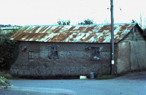 Cob barn/workshop with corrugated tin roof.