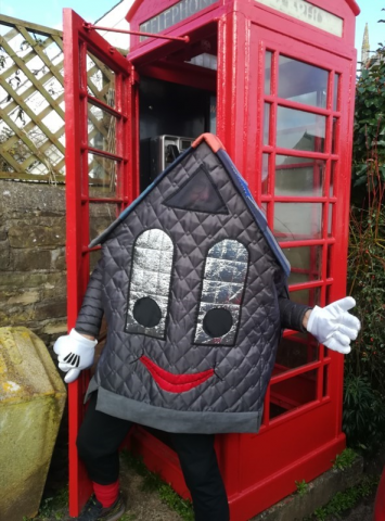 Photo of Sampford Courtenay Village Hall mascot, Roof-us, outside the village phone box