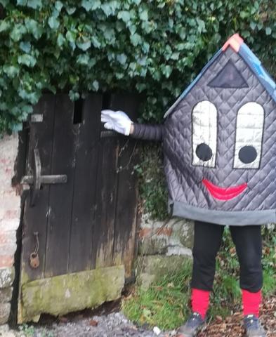 Roof-us standing by a small wooden door under overgrown ivy