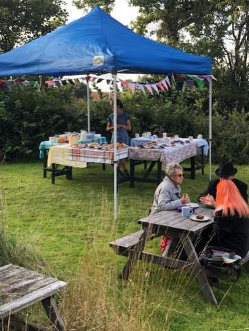 Photo of the tea and cake stall with people sitting enjoying.