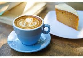 Picture of coffee in a blue cup with a piece of cake on a plate