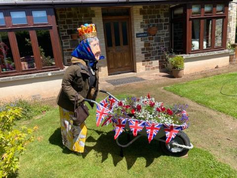Queen Elizabeth ll with a wheelbarrow.