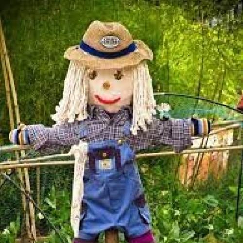 A scarecrow standing with his arms outstretched