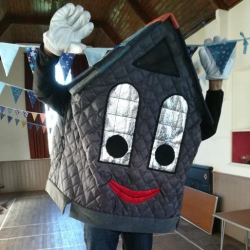 Roof-us in the village hall with his arms raised in celebration
